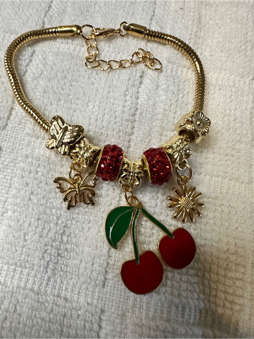 The Blossom Apparel Gold Cherry Charm Bracelet with Red and Green Accents